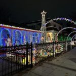 View of house and sidewalk with lighted arches.